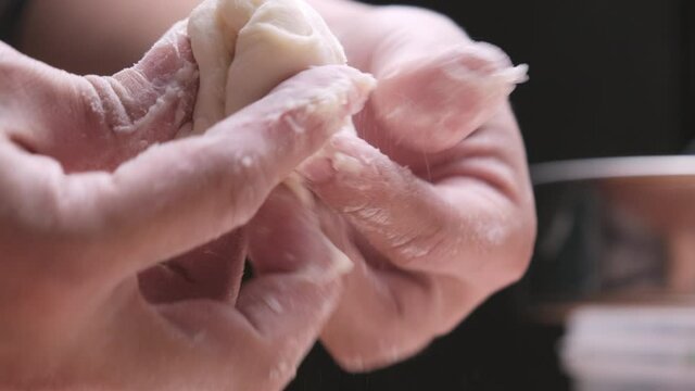 Woman chef hands doing make Chinese dumplings or steamed Chinese bun with vegetables and minced pork. The dough is prepared for the forming. The process of making stuffed steamed buns.