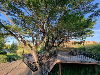 Fototapeta na wymiar Resting table and chair on balcony under shade of tree.