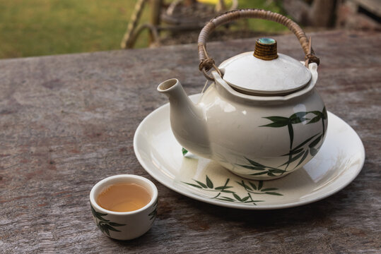 Chinese tea in teapot on wooden table among garden