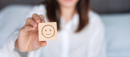 Happy Woman holding smile emotion face block. Customer choose Emoticon for user reviews. Service...