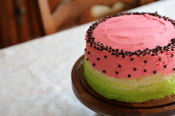 Pink, white and green watermelon style birthday cake on a table