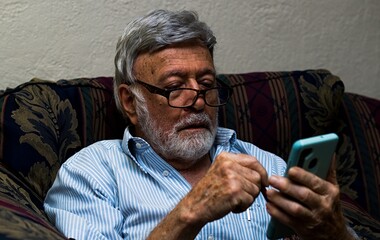 Old man messing with a phone