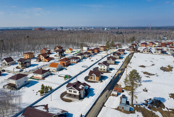 Aerial view of a cottage settlement under construction in the forest in Siberia in winter