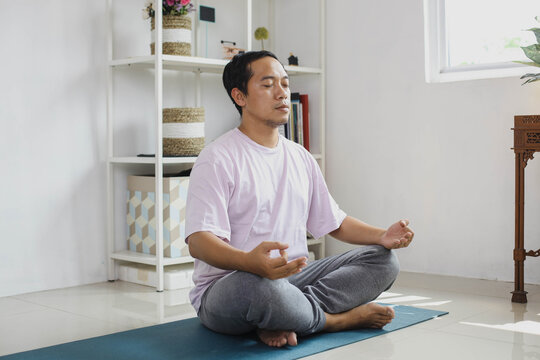 Handsome young asian man meditation at home
