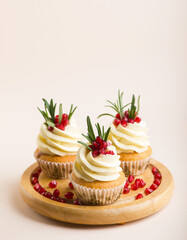 cupcakes with cream and pomegranate seeds. Delicious cupcakes with cream on white background