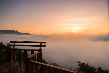 Fototapeta na wymiar The beautiful early morning sky with twilight and waves of fog at wooden terrace of Baan Ja Bo village viewpoint Pang Mapha, Mae Hong Son, Northern Thailand.