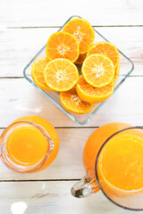 Jar of fresh orange juice on wooden table background. Top view.