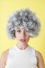 Charming young woman in wig standing in studio