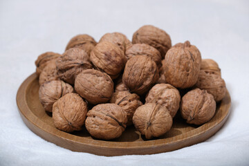 Group of walnuts on a white background. Nuts on a wooden plate. Walnut top view.