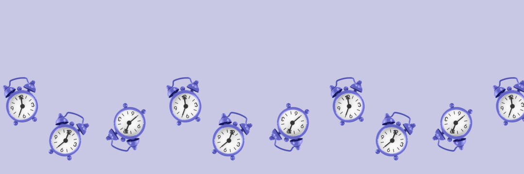 Purple alarm clocks pattern on purple background banner size, very peri color of 2022 - Powered by Adobe