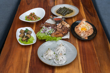 Festive feast with different dishes from Georgia, Armenia and Russia. Caucasian cuisine. Various delicious dishes on the wooden table. 