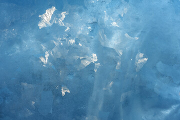 Sunlight breaks through a thick block of ice. Ice pattern and texture.