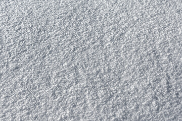 The pattern and texture of a smooth snow surface. The natural color of the snow as a background.