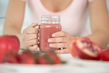 cropped view of woman with pink smoothie drink