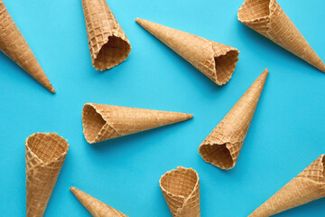 Empty ice cream waffle cones pattern on blue background. Summer food concept.