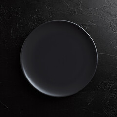 Empty round black plate on dark moody black background with copy space.