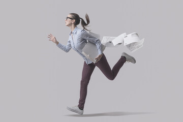 Businesswoman running and losing paperwork