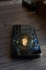 Reflection of old style spiral lamp in smartphone glass