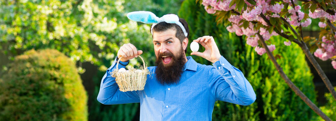 Funny man having fun in park. Easter egg hunt concept. Humorous series of a man in bunny suit....