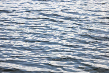 Close-up water reflection texture, pattern, with small waves.