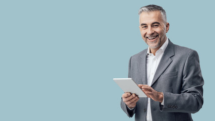 Businessman using a digital tablet and smiling