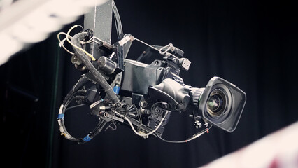 Fototapeta na wymiar TV Camera broadcast on the crane tripod for shooting or recording and broadcasting content in studio production to on air tv or online internet live show. HD Video recording on crane. Selective focus.