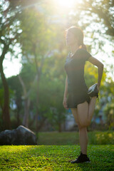 Asian woman wearing a black dress  warm-up before Jogging in the park