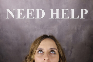 need help. woman looks at the inscription on a gray background