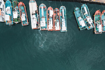 Marine jetty with multicolored boats close-up top view, copy space.