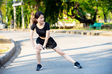 Asian woman wearing a black dress  warm-up before Jogging in the park