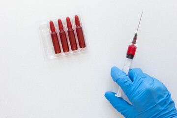 Top view of woman hand in medical glove holding syringe barrel with vitamin group B for injection