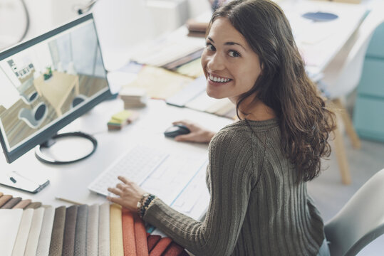 Smiling Interior Designer Working At Desk