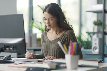 Professional interior designer sitting at desk and working