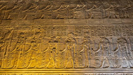 A fragment of the wall of an ancient Egyptian temple in Kom Ombo. Relief carvings of gods and...