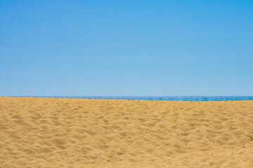 Fototapeta na wymiar Beach. Beach with footprints and sea with clear sky on the background