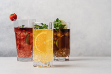 Set of various summer refreshing lemonades. Strawberry, orange, cuba libre drinks with ice on light background