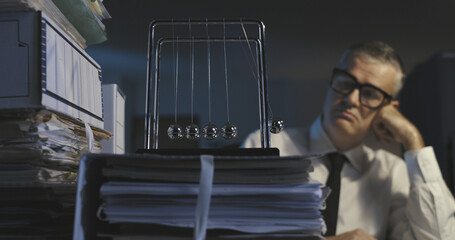 Bored office worker and Newton's cradle