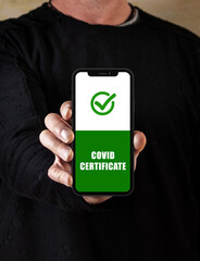 Persona con aplicación móvil en la mano y idioma Inglés certificado vacunado Covid-19 aprobado y...
