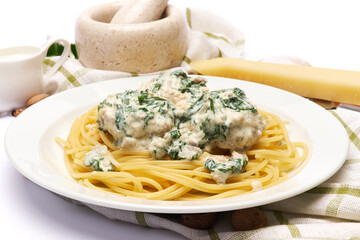 Portion of delicious meatballs with spinach in a creamy sauce and pasta
