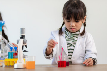 education, science, chemistry and children concept - kids or students with test tube making...