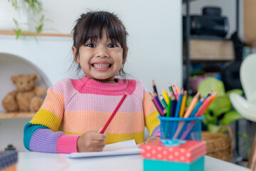 Happy Holidays. Asian little children make cards, gifts, and decorations for the holiday. Cute kids are engaged in creativity.