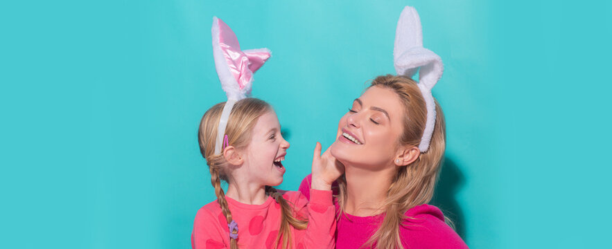 Happy mother and child daughter celebrating Easter. Cute little girl with funny face in bunny ears laughing, smiling and having fun. Easter banner with copy space.