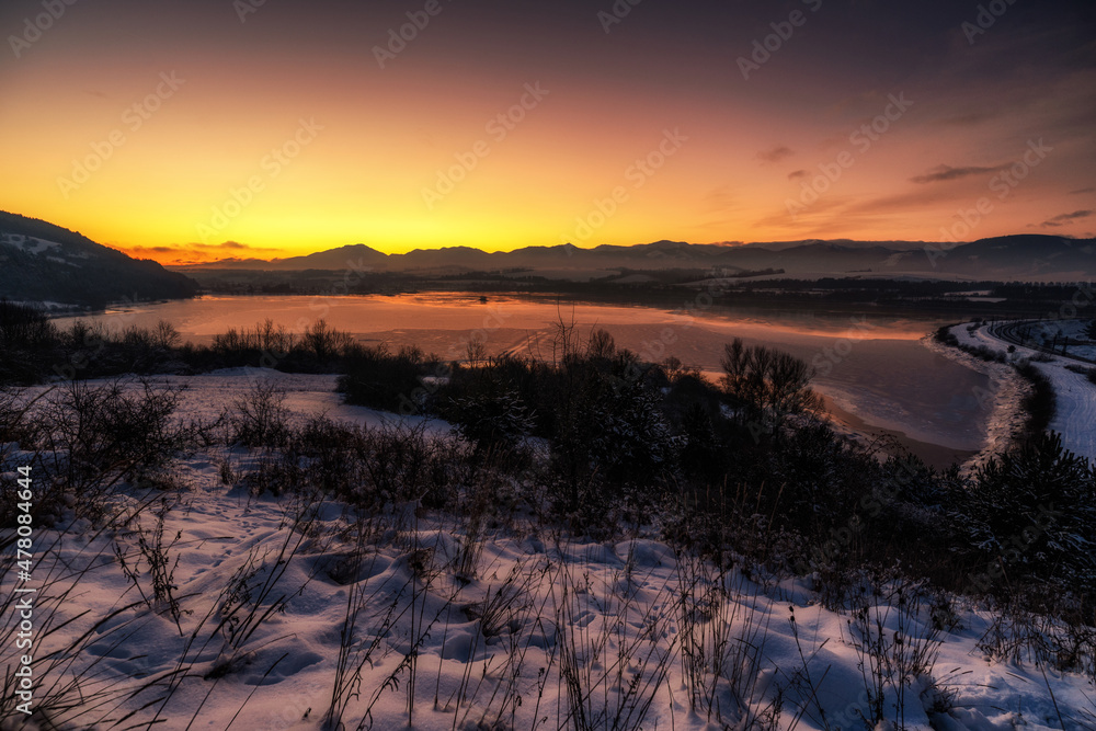 Sticker Beautiful coolorful sky during sunrise over lake. Dam Liptovska Mara and Low Tatras mountains at background