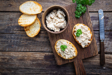 Sandwiches with salmon pate and baguette, fish bruschetta, top view. Rustic homemade Italian cuisine.