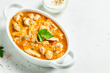 Chicken spicy goulash in pot. Top view, copy space.
