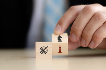 Business goals and strategies concept.  Game changer  for business adaptation and growth. Hand flips wooden cubes  with strategy to another strategy standing with  goal on smart background.