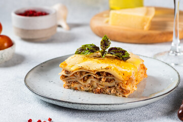 Piece of tasty hot lasagna on light background. Traditional italian lasagna. Italian food. Close up lasagna. Bolognese sauce. Bechamel sauce. Still life of food. Homemade meat lasagna