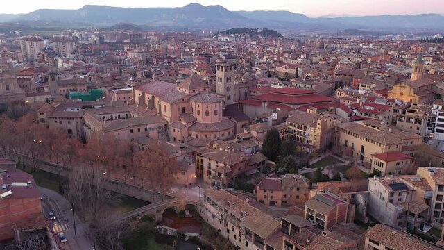 View from drone of Spanish town of Vic with tiled roofs of old buildings and ancient cathedral in winter evening, Barcelona province, Catalonia