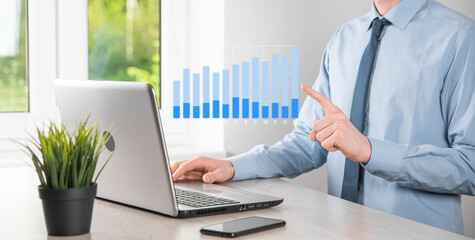 Business man holding tablet and showing holographic graphs and stock market statistics gain profits. Concept of growth planning and business strategy. Display of good economy form digital screen.