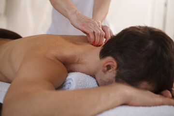Cropped close up of unrecognizable man getting professional massage at spa center
